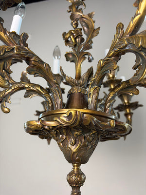 Antique Circa 1920 Ten Light European Bronze Rococo Revival Chandelier with Cast Figural Cherub
