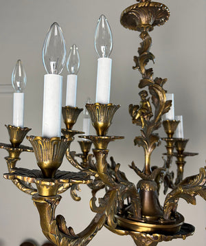 Antique Circa 1920 Ten Light European Bronze Rococo Revival Chandelier with Cast Figural Cherub
